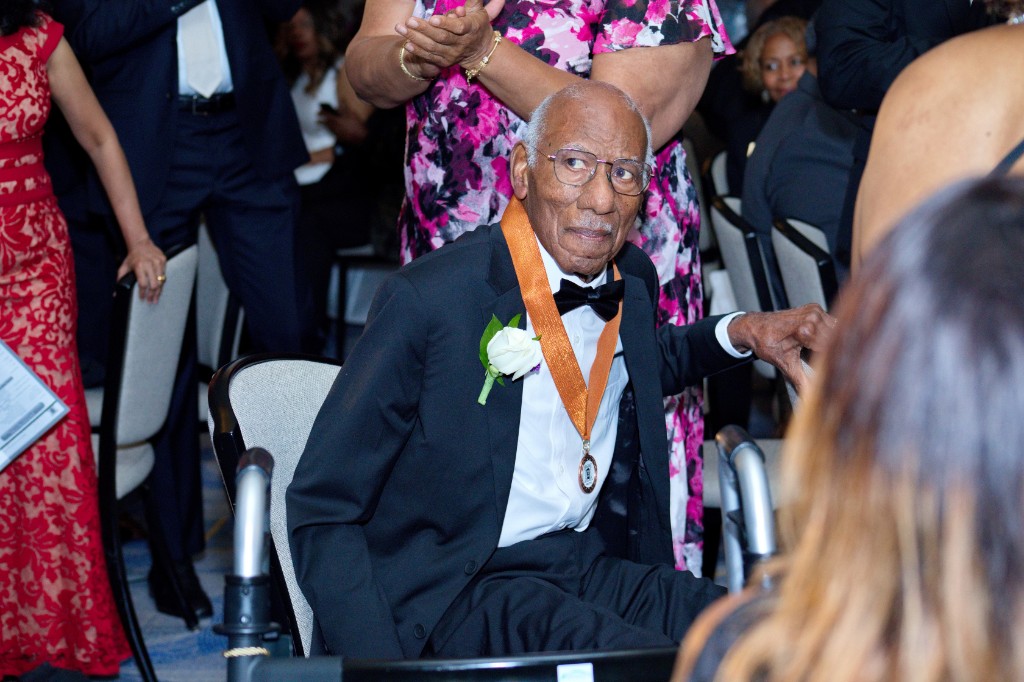An honoree in a tuxedo and medal at Hall of Fame Weekend